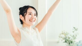 両腕を上げて両脇の下を露出している若い女性