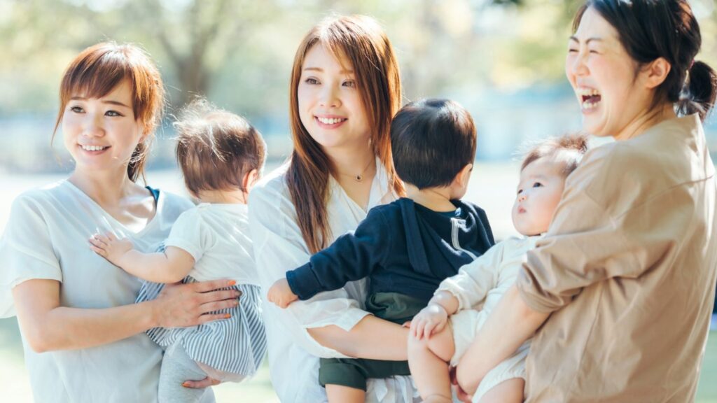 子供を抱っこしている3人の母親