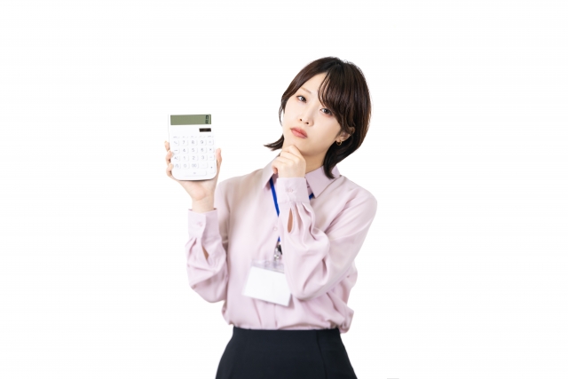 片手に電卓を持って悩んでいる女性