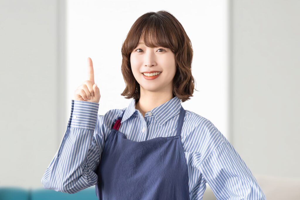 人差し指を立ててポイントを案内している女性