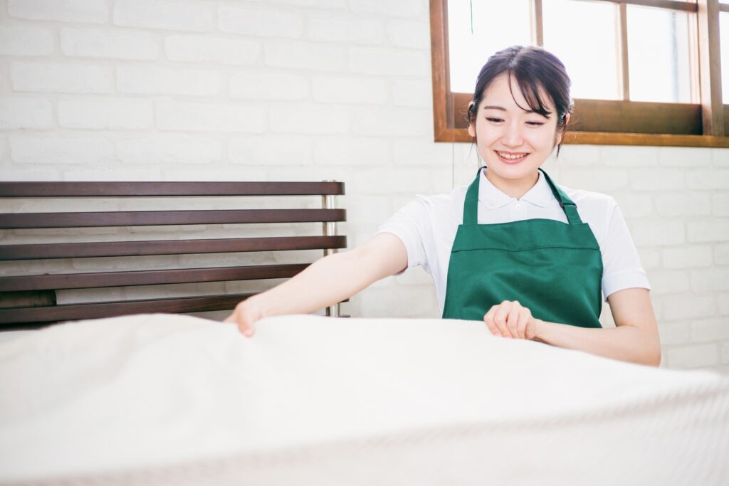 マットレスをメンティナンスしている女性