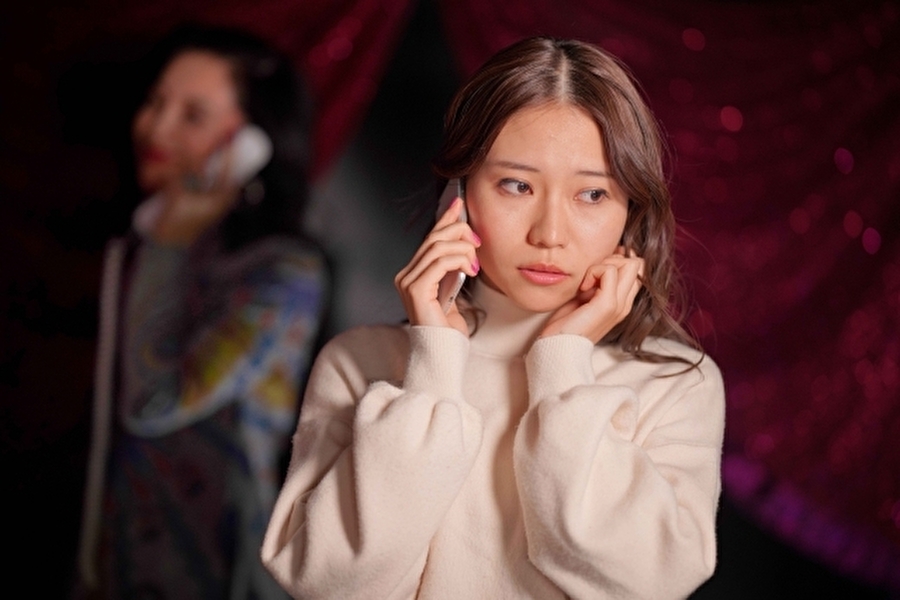 占い師と電話している女性